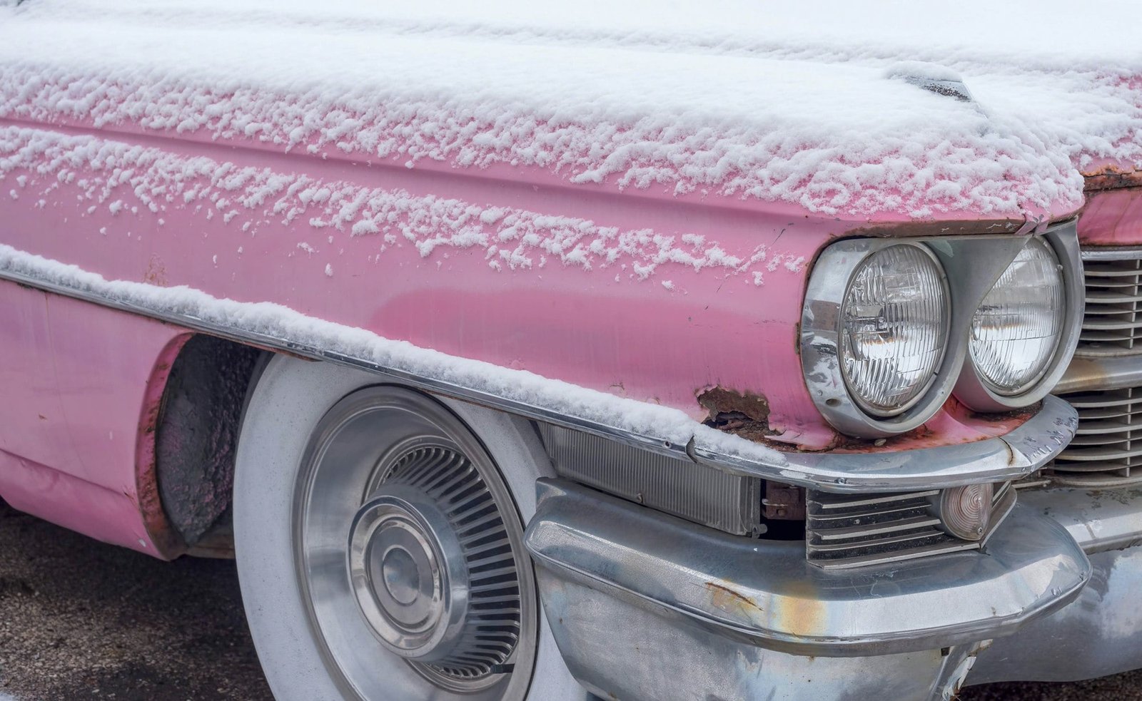 Vintage pink Cadillac covered in snow