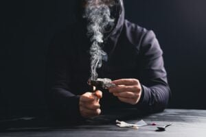 Drug addict man or drug dealer prepares heroin.