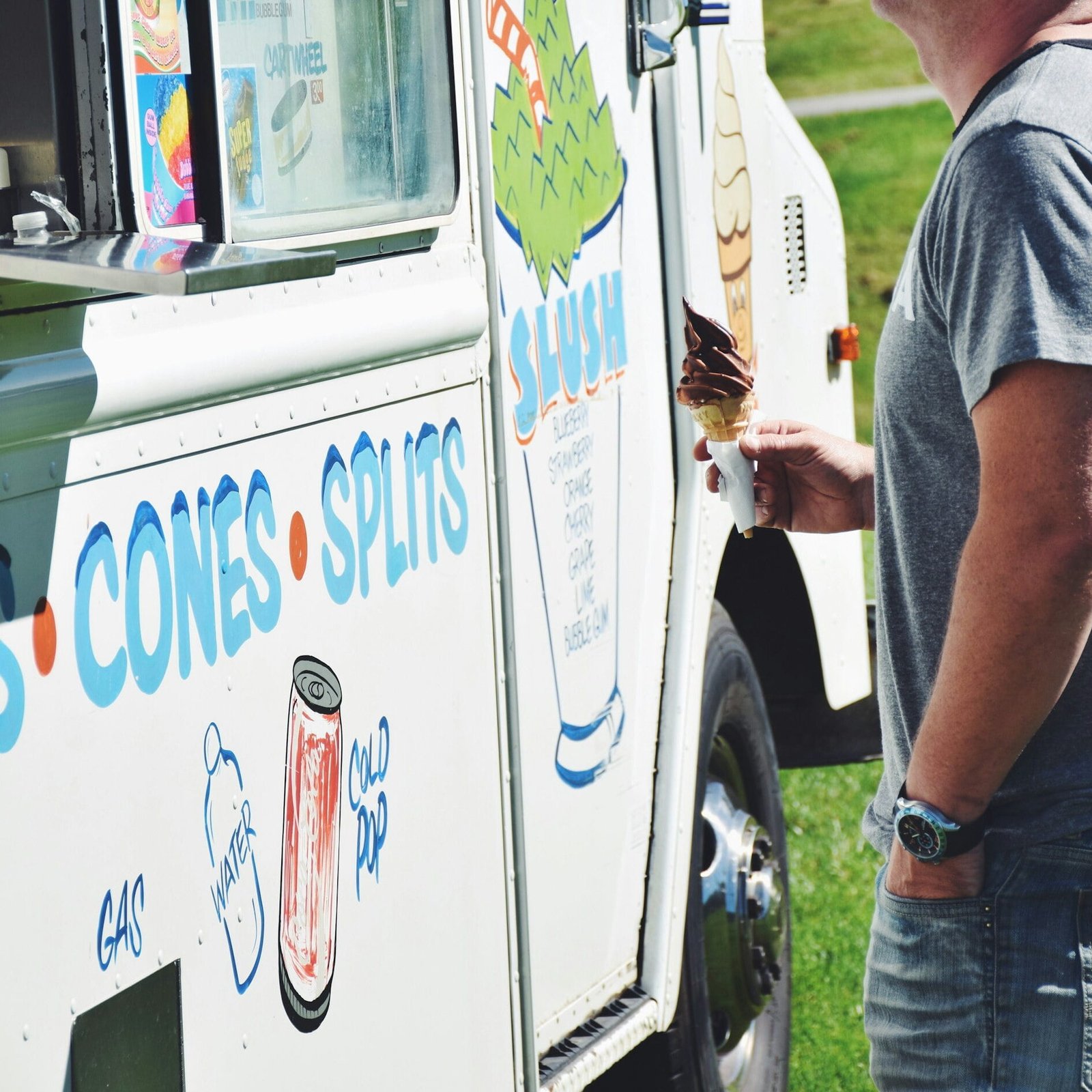 A man is buying ice cream from an ice cream truck